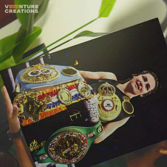 Boxer Katie Taylor holding her championship belts